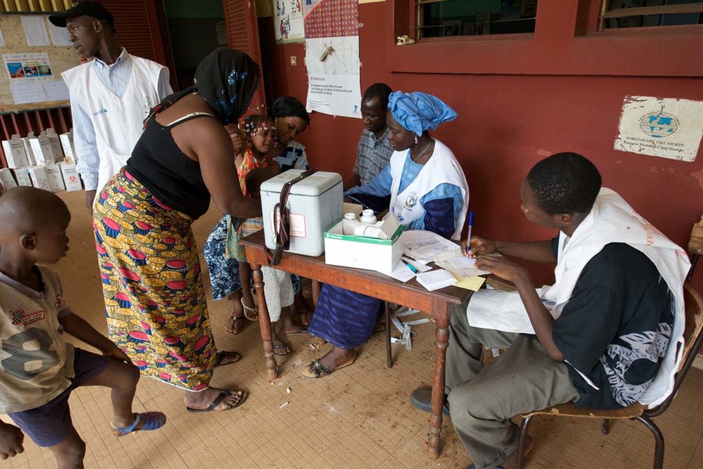 Over 800 children have fall ill with measles in the last two months, it is a major epidemic. In the developed world measles is a minor inconvenience, in a country like Guinea it is often fatal. 
Measles is preventable, a well functioning routine vaccination programme should prevent epidemics breaking out, and should an epidemic occur an emergency response should prevent it becoming generalised. However Guinea has been going economic and political turmoil since 2006 that has weakened the health services. As a result the routine vaccination is no longer fully effective, hence the current epidemic.
The government, UNICEF, WHO and other actors got together to conduct a country wide campaign from November 20 to 26th to vaccinate against measles combined with the distribution of bed nets against malaria and vitamin a and deworming tablets to minimise malnutrition. 
I spent the day visiting a hospitals, health centres and vaccination points to better understand what needs to be done. The condition of the children in the hospital was critical. There is a local practice of treating fever with palm wine and ice water baths, partially this is because people believe it works and partly because they want to delay having to pay for medicine or treatment. This has the unfortunate result that many children who are referred to the hospital arrive at a very and dangerous state in the development of the disease, also the ice burns the skin of the children aggravating their condition. 
I spoke with the parents and children; they were confused and worried by what was happening to their children. 
The parents agreed to my taking photographs. Looking at the images I find them shocking; I do not know what is right to do. To not show them is to hide a reality about measles that people need to know about, to mobilise support. But it is not possible to be   dignified when you have measles.
One of the children that we saw died that night, it should have been avoided.