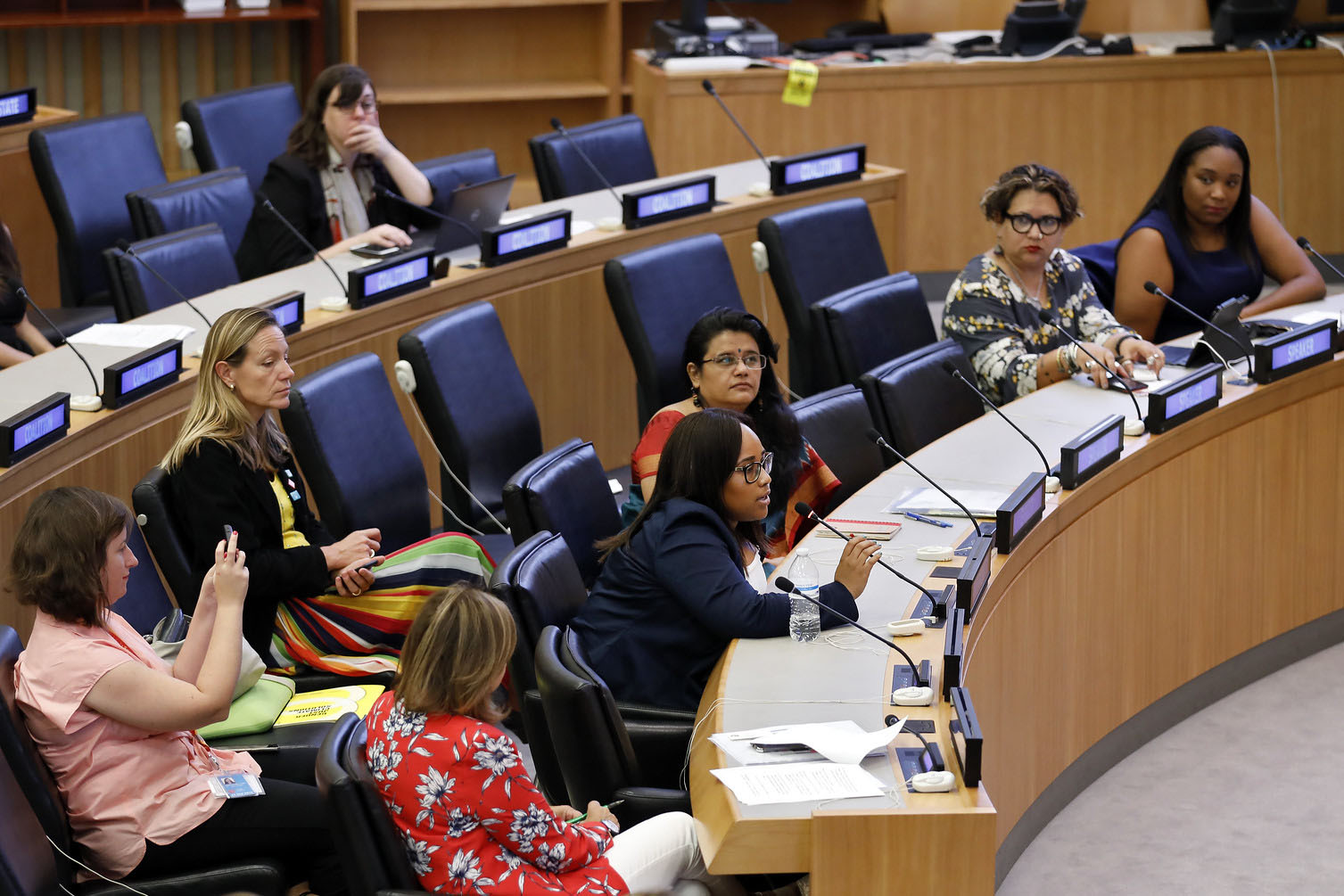 a woman speaking into a microphone at a UN event