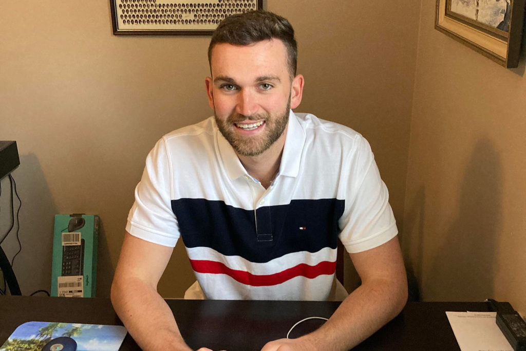 Andrew Horne sitting at his desk in his home office