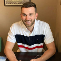 Andrew Horne sitting at his desk in his home office