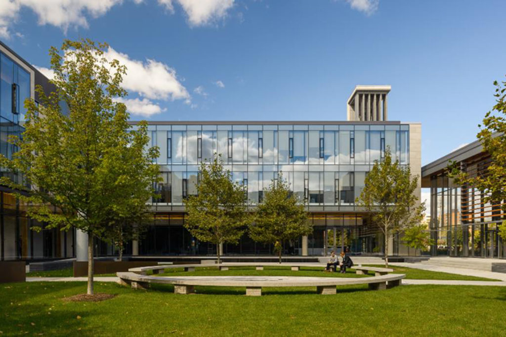 BSIA wing of CIGI campus in the background with grass and the circular bench in the foreground