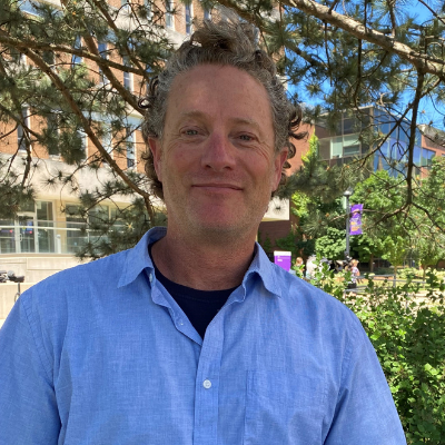 Brent Wolfe standing outdoors with a tree behind him