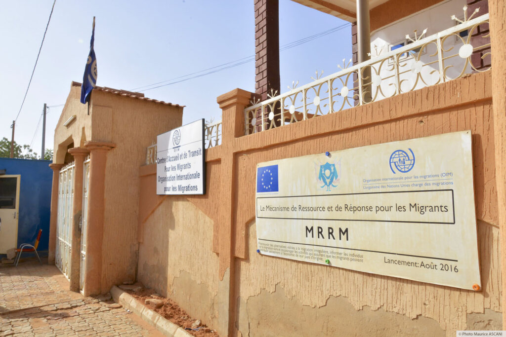 A wall with signs that indicate resources for migrants