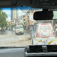 Photo taken through a car windshield of cars driving through flooded streets.. Driving from the airport, arriving in Dar es Salaam during the peak of Niño’s storms.