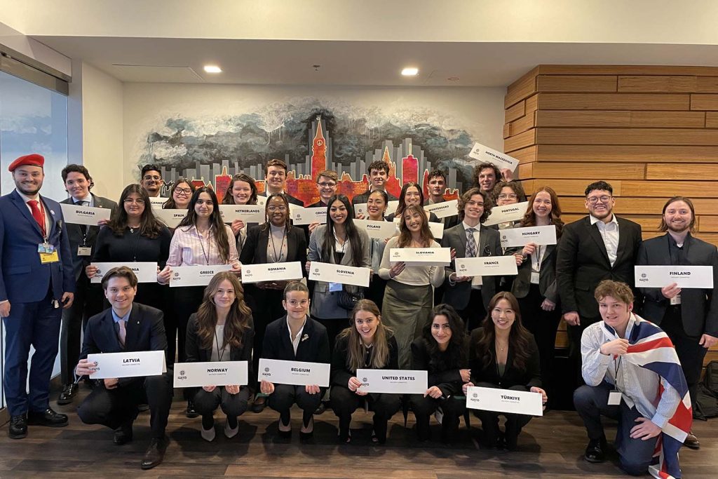 Carleton MNATO military committee posing with signs.