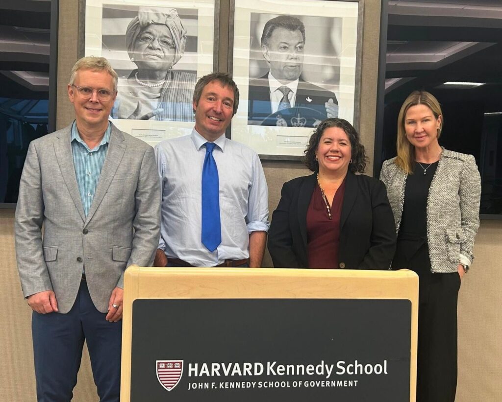 Photo of CIGI-Harvard-BSIA representatives standing behind a podium that reads "Harvard Kennedy School"