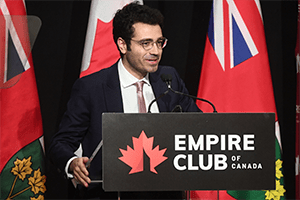 Daniel Safayeni standing at a podium labelled with Empire Club of Canada and the Canadian flag.