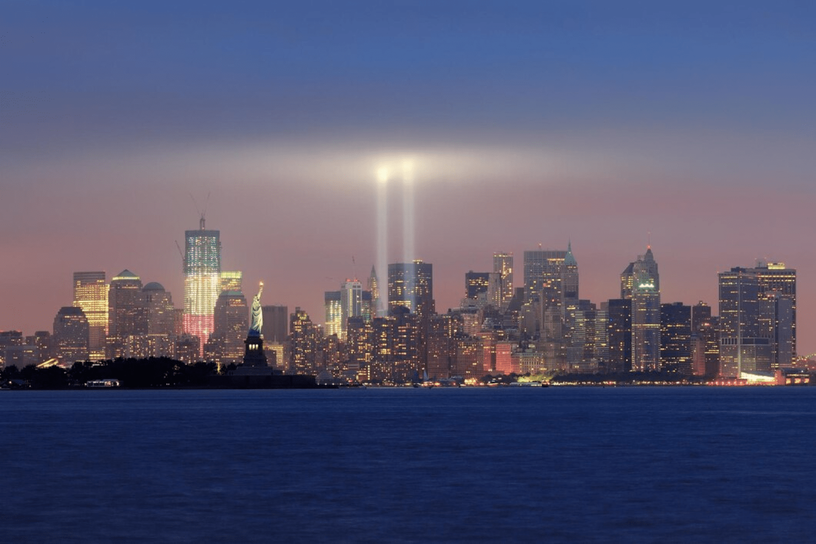 A skyline of New York City with two light beams where the Twin Towers stood,