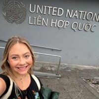 Selfie of Madelyn Rawlyk stanind in front of the United Nation building