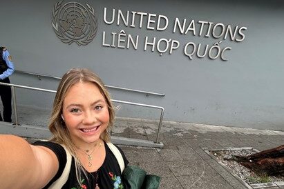 Selfie of Madelyn Rawlyk stanind in front of the United Nation building