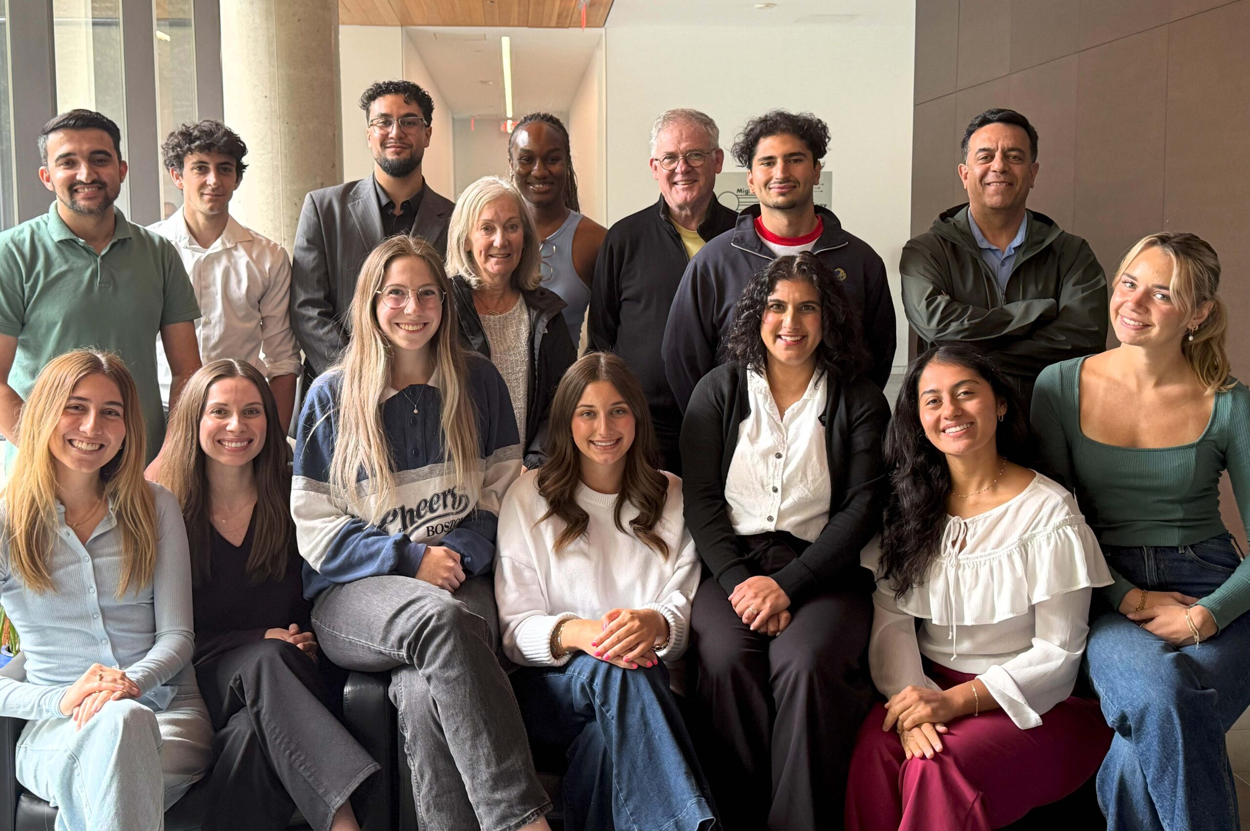 14 students and FIPP instructor standing and sitting in a hallway